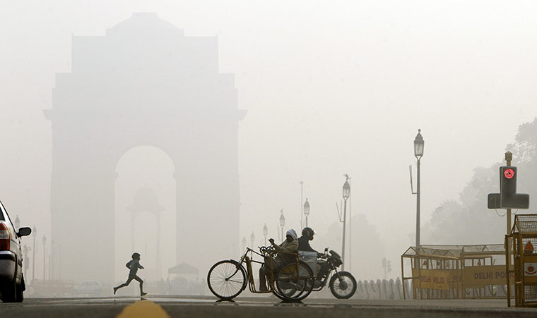 24 hours in pictures: New Delhi, India: A young child runs near India Gate in the morning fog