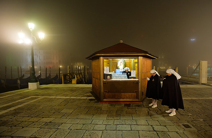 24 hours in pictures: Venice, Italy: Members of a religious order wait to welcome pilgrims