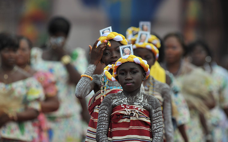 24 hours in pictures: Cotonou, Benin: Catholic faithfuls sporting a photo of Pope Benedict XVI