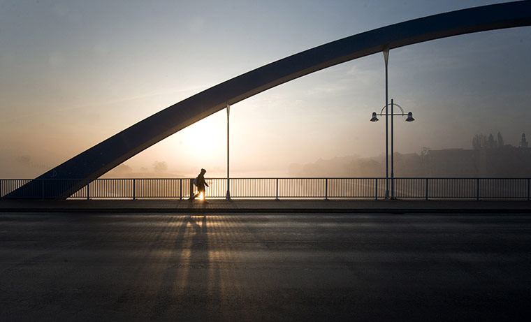 24 hours in pictures: Frankfurt/Oder, Germany: The sun rises behind a pedestrian on a bridge