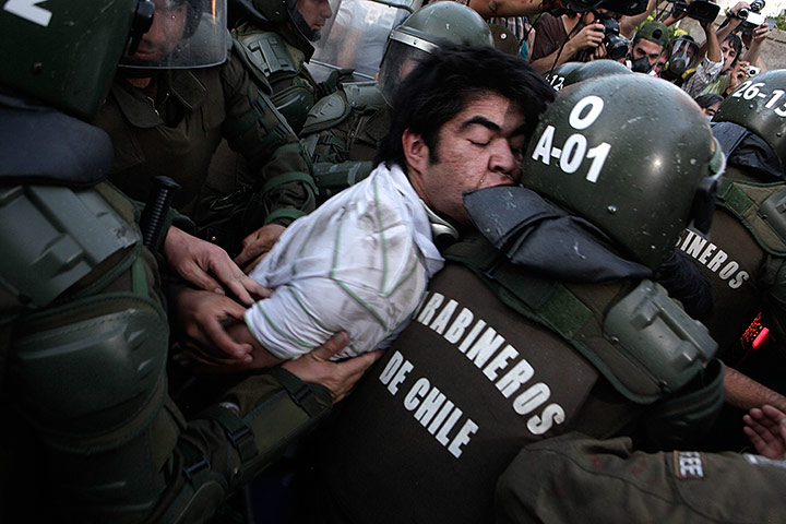 24 hours in pictures: Santiago, Chile: Police officers detain a human rights activist
