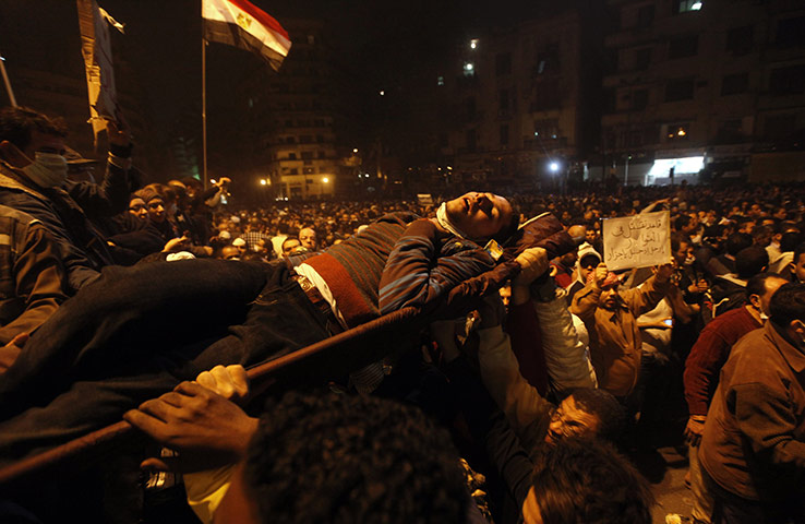 24 hours in pictures: Cairo, Egypt: A man wounded during clashes with riot police