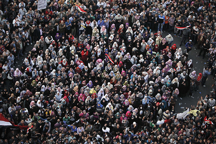Egypt protests day 4: Women protesters stand in a group during nearby clashes with riot police