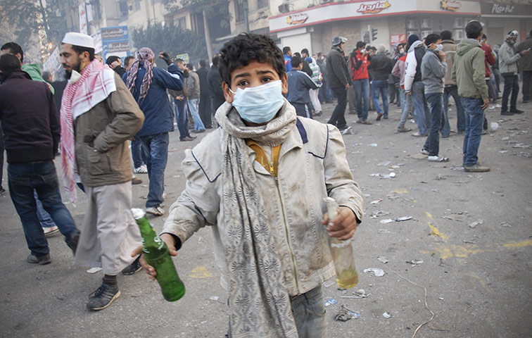 Egypt protests day 5: An Egyptian boy holds two Molotov cocktails during clashes 