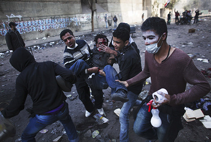 Egypt protests day 5: An injured protester is aided by others during clashes with riot police