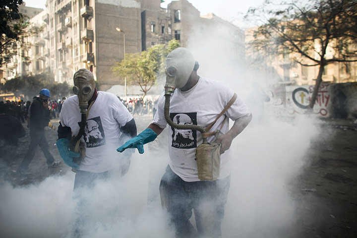 Egypt protests day 5: Protesters attempt to get rid of a tear gas canister during clashes 