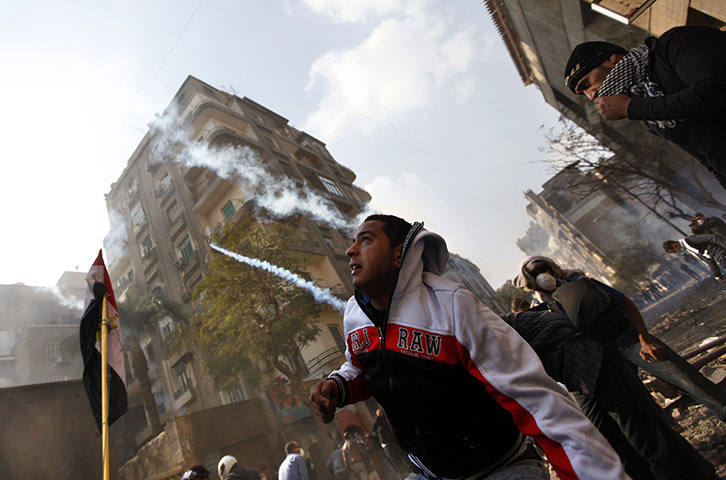 Egypt protests day 5: Egyptian protesters take cover from tear gas during clashes