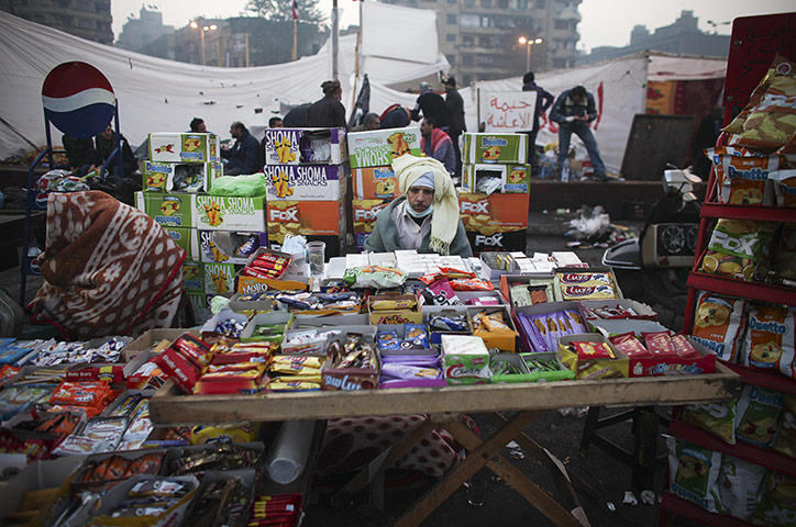 Egypt protests day 6: A vendor sits behind his wares in Tahrir Square
