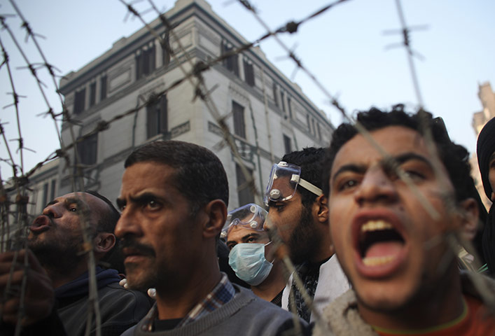 Egypt protests day 6: Protesters shout through a barbed wire barricade