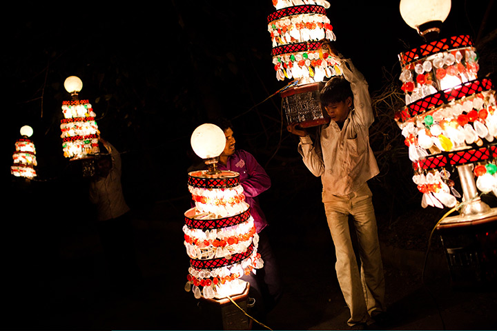 24 hours in pictures: ight wallas holds portable chandeliers, New Delhi, India