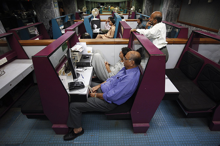24 hours in pictures: Stockbrokers follow share prices at the Karachi Stock Exchange