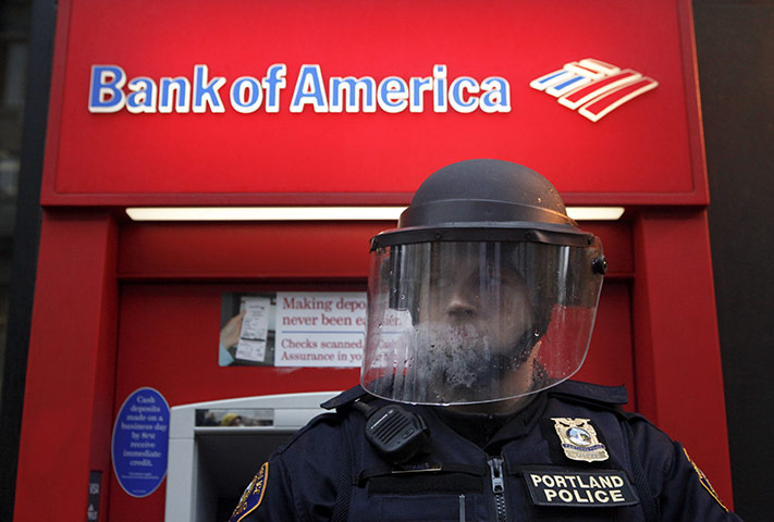 Week in Business: A policeman in riot gear defends a Bank of America in Portland, Oregon