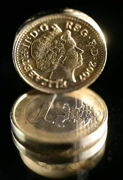 Week in Business: A British one pound coin balances on a one Euro coin