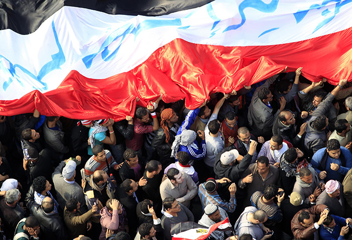 Tahrir Square: Protesters march with a huge flag in Tahrir Square 