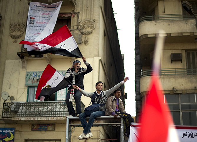 Tahrir Square: Anti-government protestors shout slogans and wave flag 