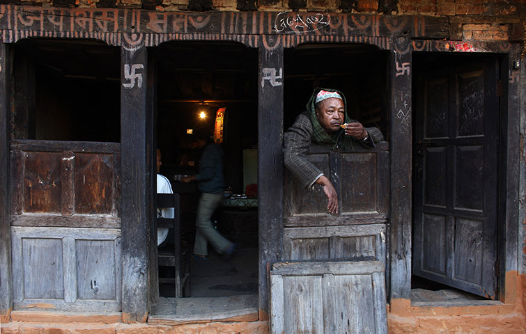 24 hours: A Nepalese man looks out from the window of a teahouse