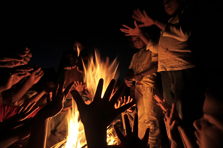 24 hours: Children gather around a fire to warm themselves in a slum