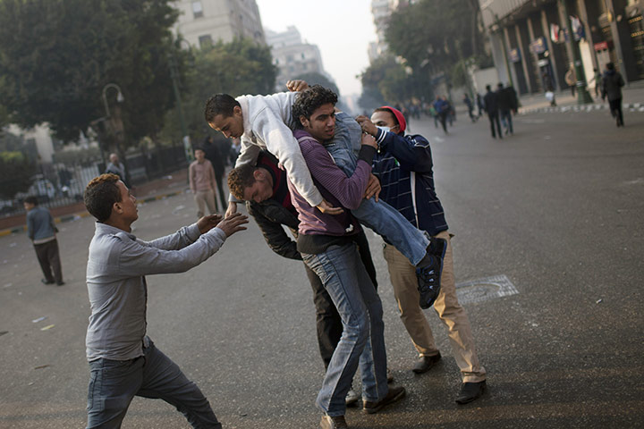 Tahrir Square: An injured protester is aided by others
