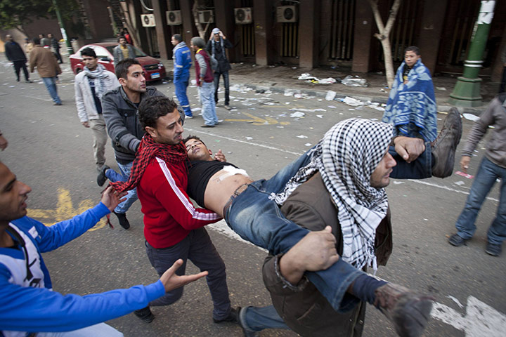 Tahrir Square: An injured protester is aided by others
