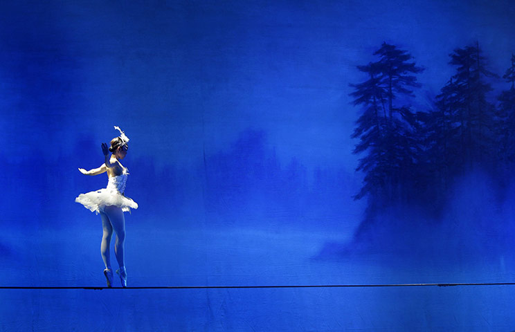 24 hours in pictures: Beijing, China: A dancer performs the Chinese 'Acrobatic Swan Lake'