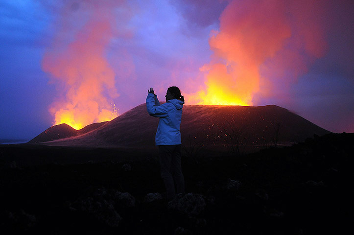 24 hours in pictures: Democratic Republic of Congo: A tourist at the erupting Nyamulagira volcano