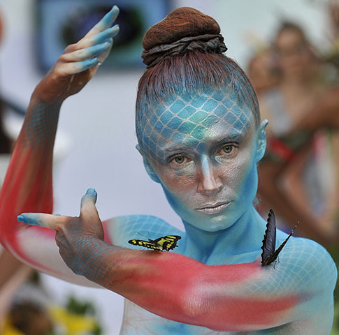 24 hours in pictures: Cali, Colombia: A model performs with butterflies during a Biofashion show