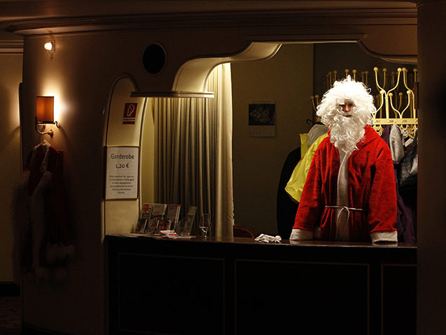 24 hours in pictures: Berlin, Germany: A volunteer dressed as Santa Claus waits in the cloakroom