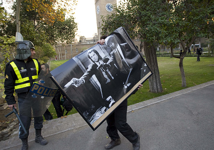 Tehran embassy: A protester walks with a poster from the British embassy in Tehran