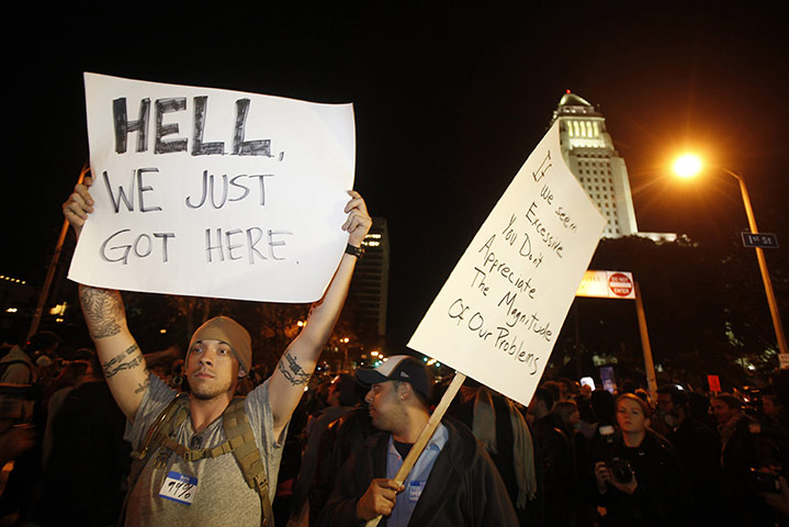 Occupy LA evictions: Occupy LA protesters hold placards near the Occupy LA tent encampment