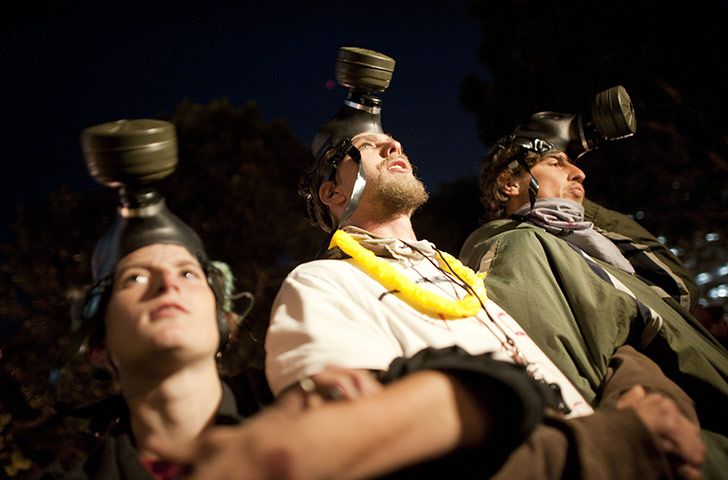 Occupy LA evictions: Occupy LA member wear gas masks as they protest outside City Hall