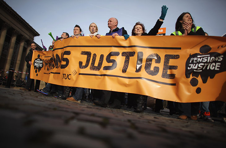 Strikers march: Strikers walk behind a large banner at a march in Liverpool