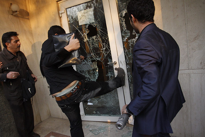 British Embassy, Iran: An Iranian protester kicks to break a door at the British embassy compound
