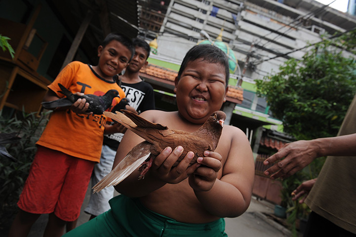 24 hours in pictures: Boys show off their pigeons outside Jami Roudhotul Falah mosque  in JAkarta