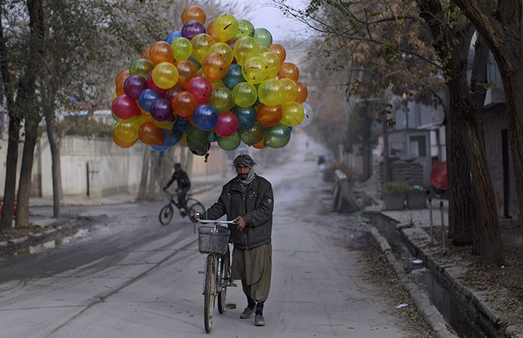 24 hours: Kabul, Afghanistan: An Afghan man who sells balloons looks for customers 