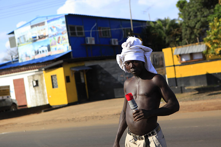 Liberia violence: An opposition supporter carries a spent tear gas canister