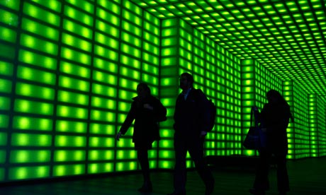 Office workers walk through green foyer.