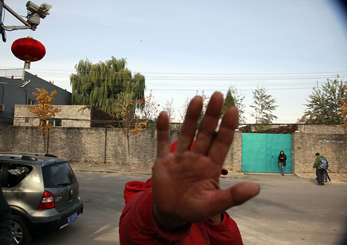 Ai Weiwei: A worker pretends to obstruct a photographer