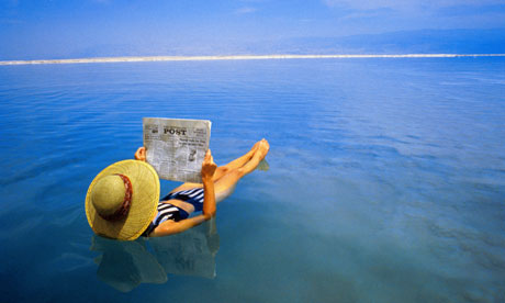 woman reading paper in the sea