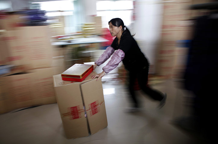 Week in business: An employee pushes a box at a textile factory in Yiwu, China