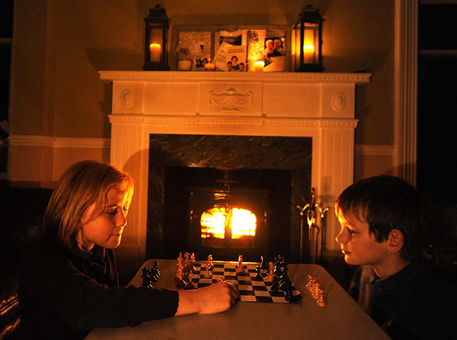 24 hours in pictures: Elsie and Euan play chess by candle light following a power cut in Scotland