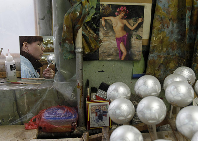 24 hours in pictures: An employee works at a factory producing New Year and Christmas decorations
