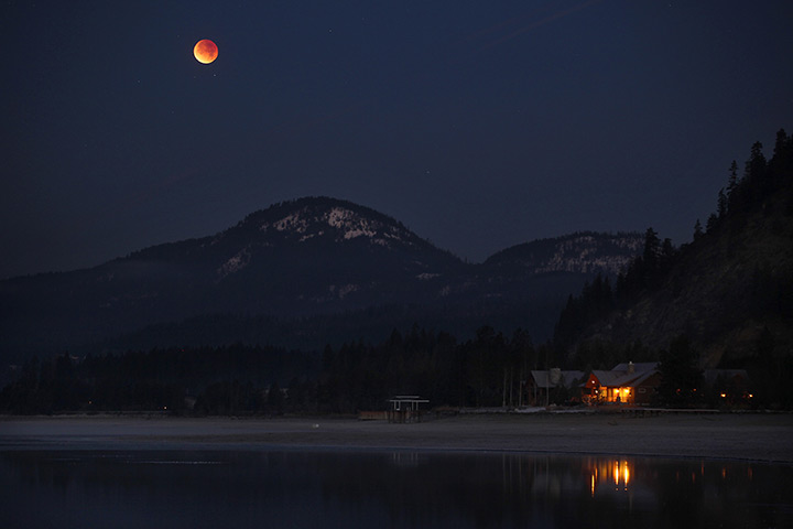 24 hours: Sandpoint, Idaho, USA: The moon casts a reddish hue over Lake Pend Oreille