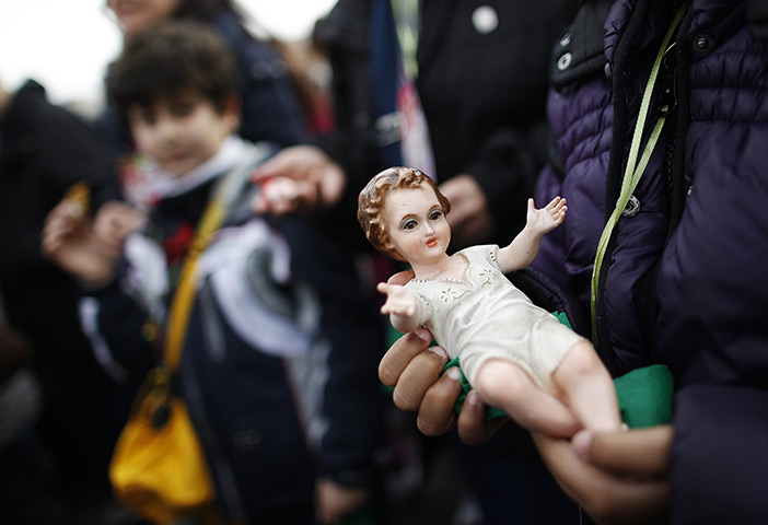 24 hours: The Vatican: A woman holds a figurine of Baby Jesus 