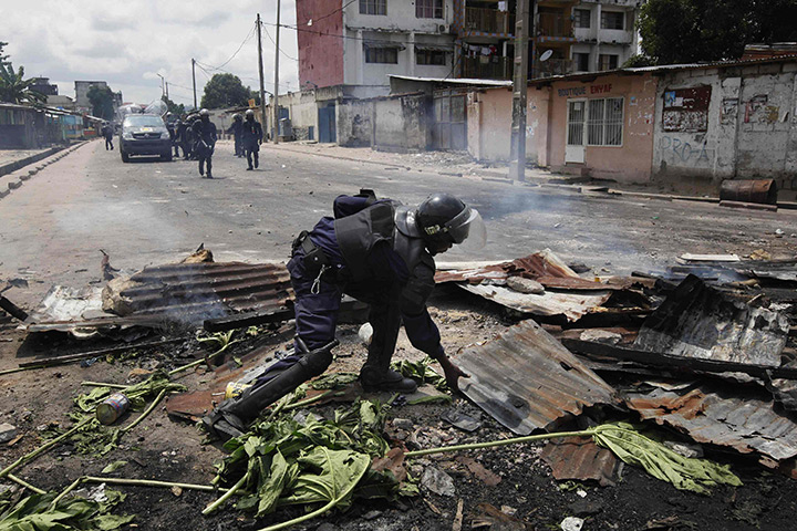 24 hours: Kinshasa, DRC: A riot policeman dismantles a roadblock