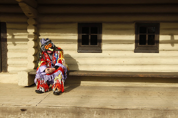 24 hours: Bucharest, Romania: A masked man rests after performing at a fair