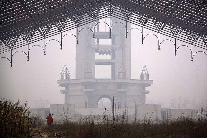 24 hours: Beijing, China: A farmer walks through an abandoned building