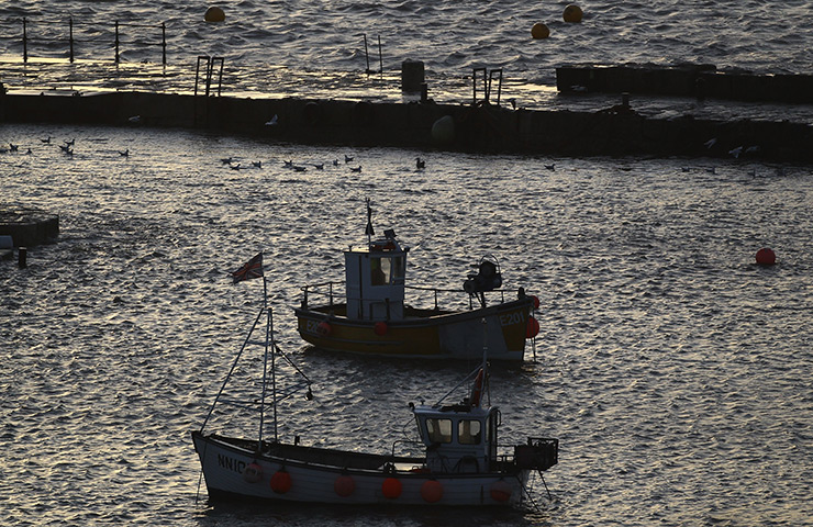 24 hours: Lyme Regis, England: Boats shelter in the harbour as storm waves break