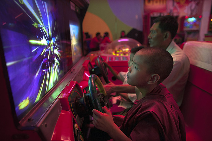 24 hours: Rangoon, Burma: A novice monk plays a game at Happy World amusement park