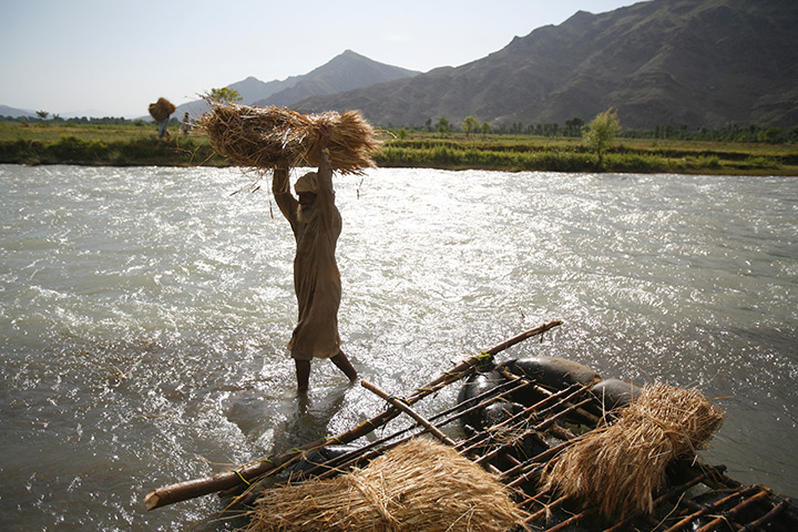 Declan Walsh: Men cross the Swat river with wheat-laden inflatable craft, Pakistan