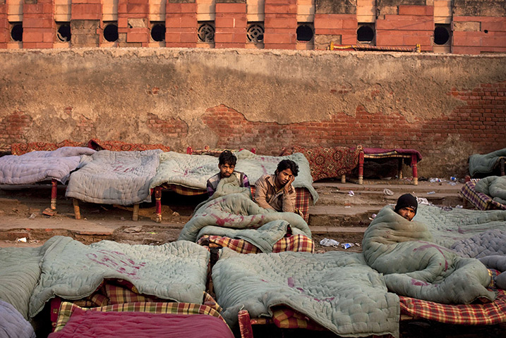 24 hours in pictures: Homeless people rest wrapped in rented quilts, India